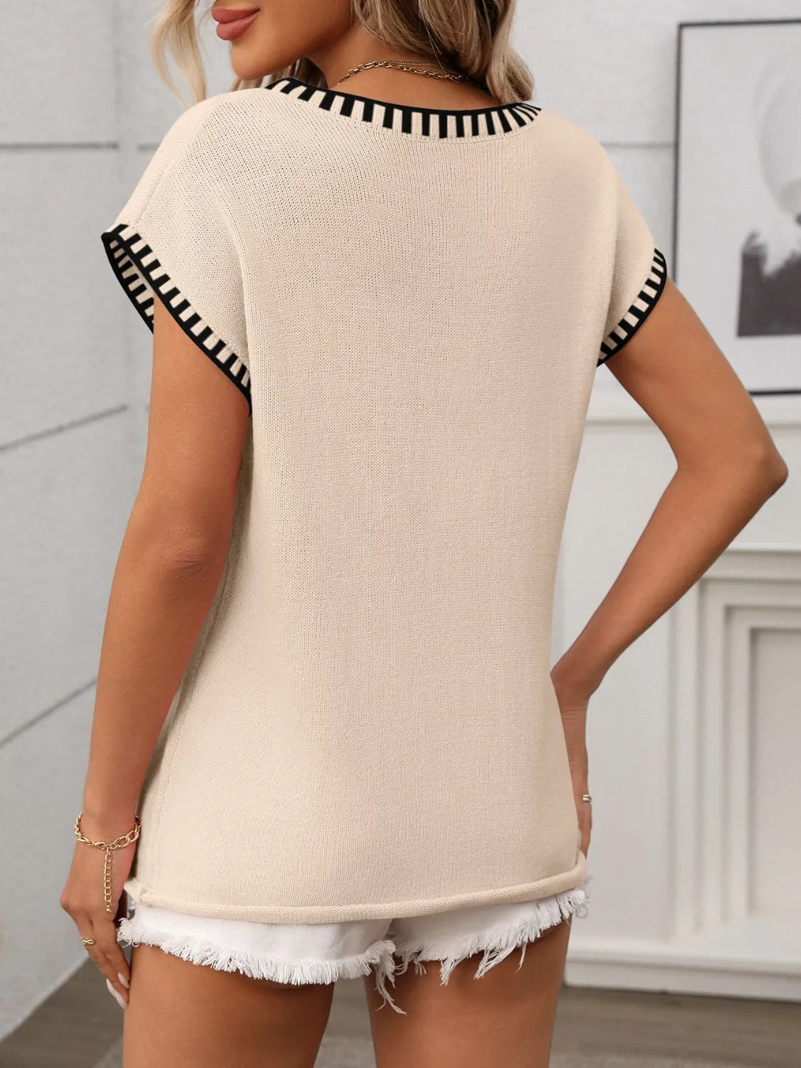 Tan knit top with black striped trim on neckline and sleeves.