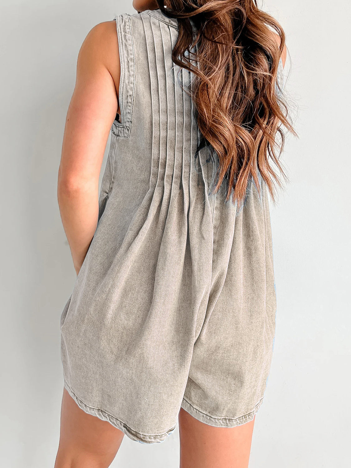 Pleated denim playsuit in mocha, sleeveless with a tie-front detail and A-line shorts.