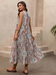 Paisley print midi dress with tie neck, tiered skirt, and decorative tassels.