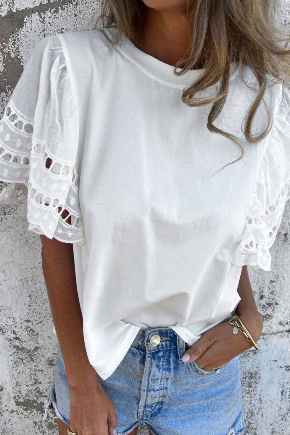 White cotton t-shirt with lace inset flutter sleeves and a crew neck.