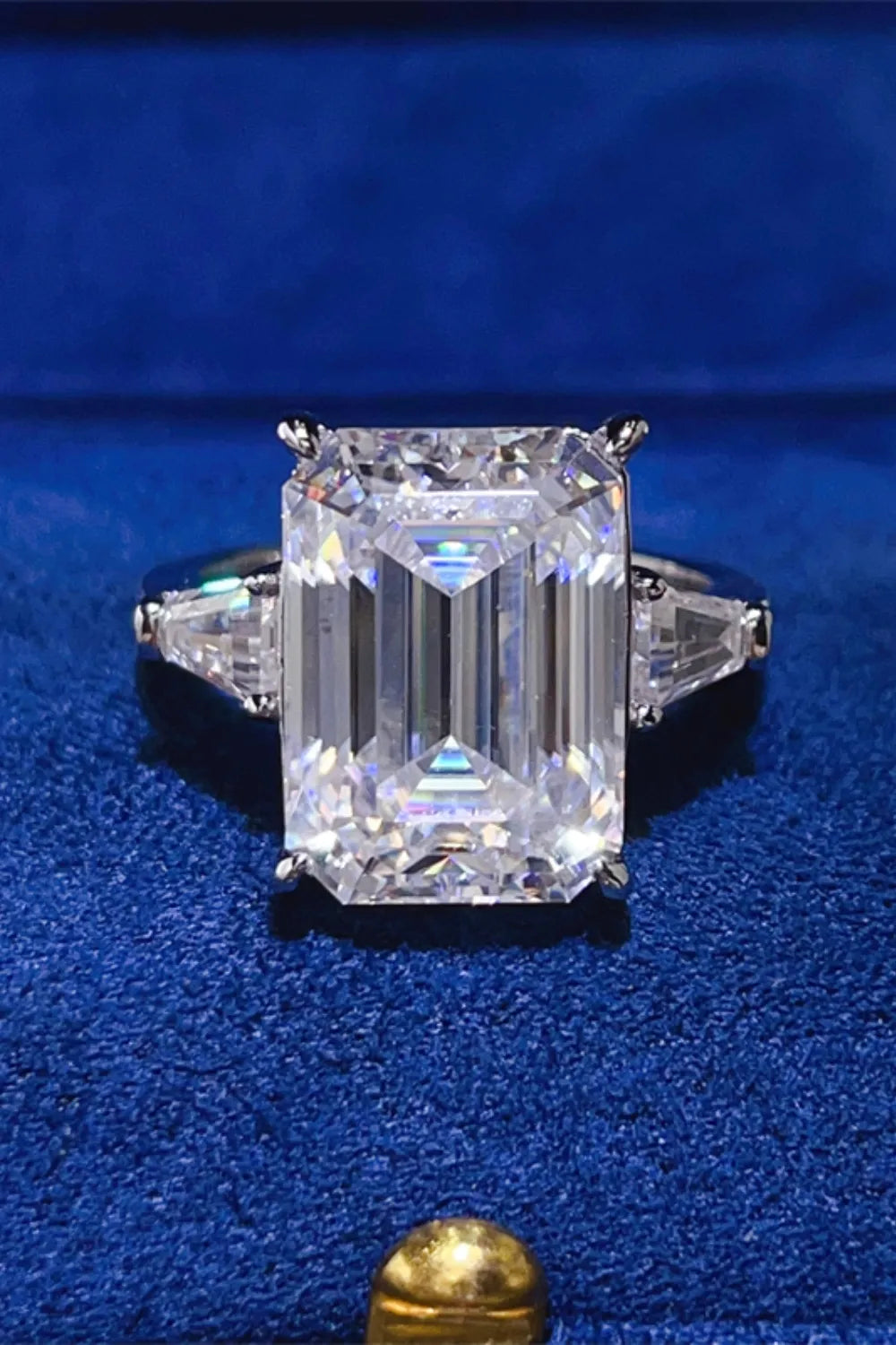 Emerald cut moissanite ring with trillion side stones in silver.