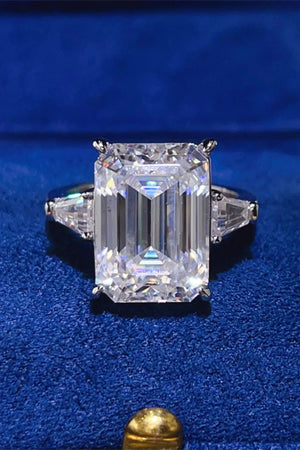 Emerald cut moissanite ring with trillion side stones in silver.