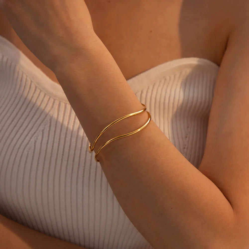 Gold double-band cuff bracelet with smooth, polished finish.