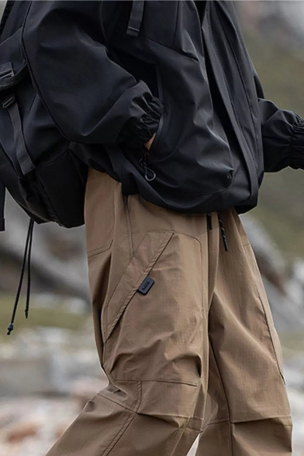 Men's brown cargo pants with drawstring waist and multiple pockets.