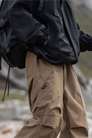 Men's brown cargo pants with drawstring waist and multiple pockets.