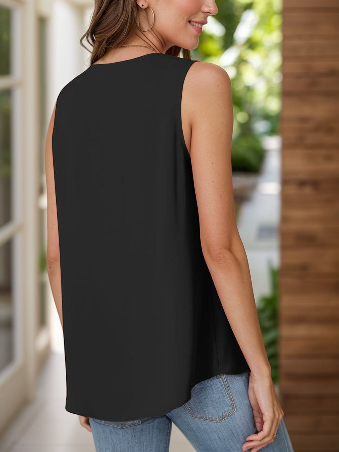 Black sleeveless blouse with pleated front detail, shown from the back.