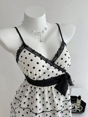 White polka dot camisole with black lace trim, black ribbon tie, and ruffled hem.