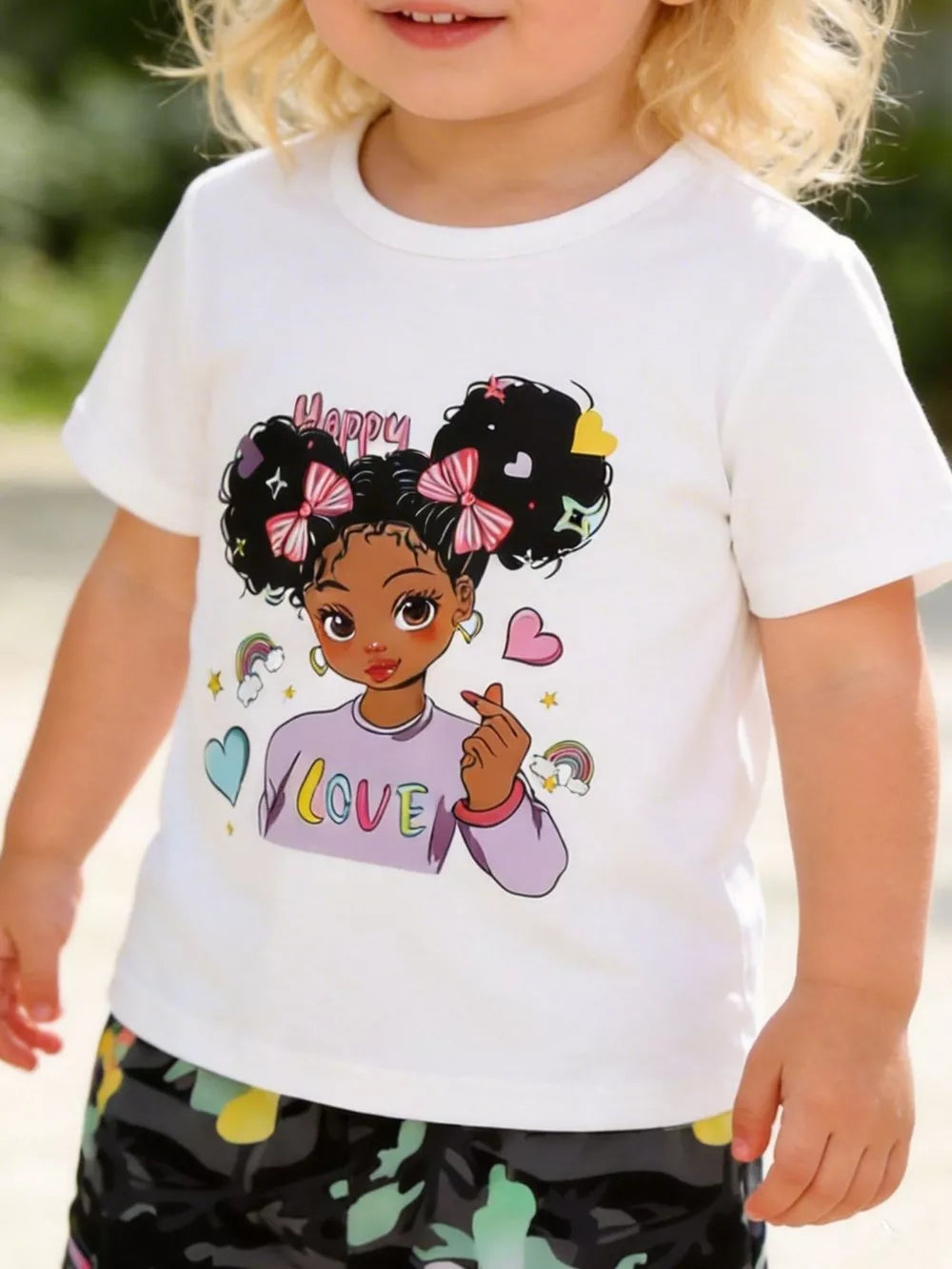 White cartoon graphic t-shirt with "Happy Love" print and camo pants.