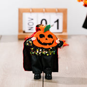 Halloween doll with pumpkin head, black cape, and sequin collar.
