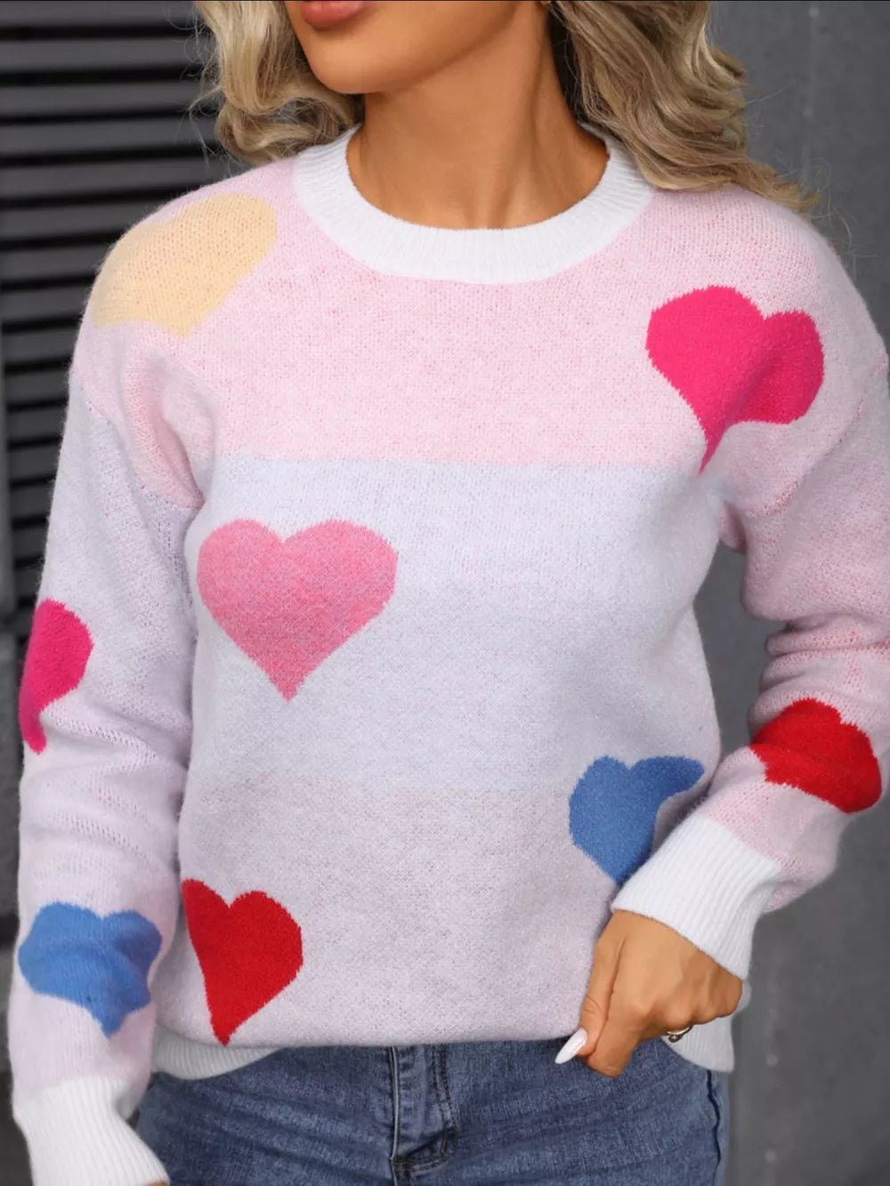 Pink and gray heart pattern knit sweater with round neck and ribbed cuffs.