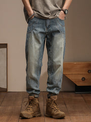 Relaxed fit vintage wash denim jeans with a tapered leg and unique seam details.