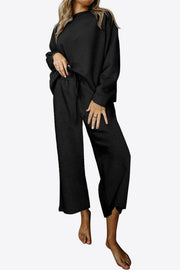 Black loungewear set with textured pattern, crew neck top and wide leg pants.