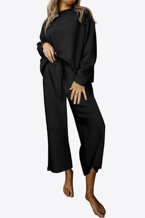 Black loungewear set with textured pattern, crew neck top and wide leg pants.