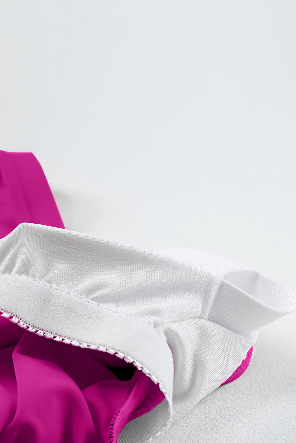 Sculpted tankini top detail in cerise with white lining and elastic band.