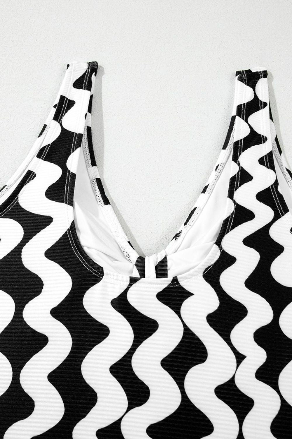 Black and white wave print one-piece swimsuit with V-neckline and bow detail