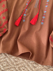Embroidered folk-inspired tie neck shirt in apricot, brown, white, or khaki.