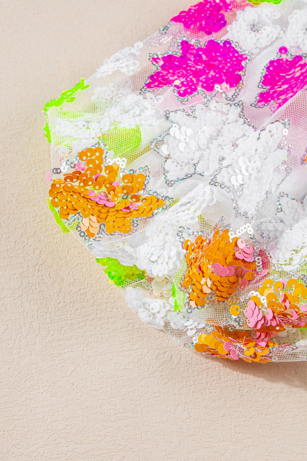 White mesh blouse with textured floral sequin embellishments in pink, orange, and green.