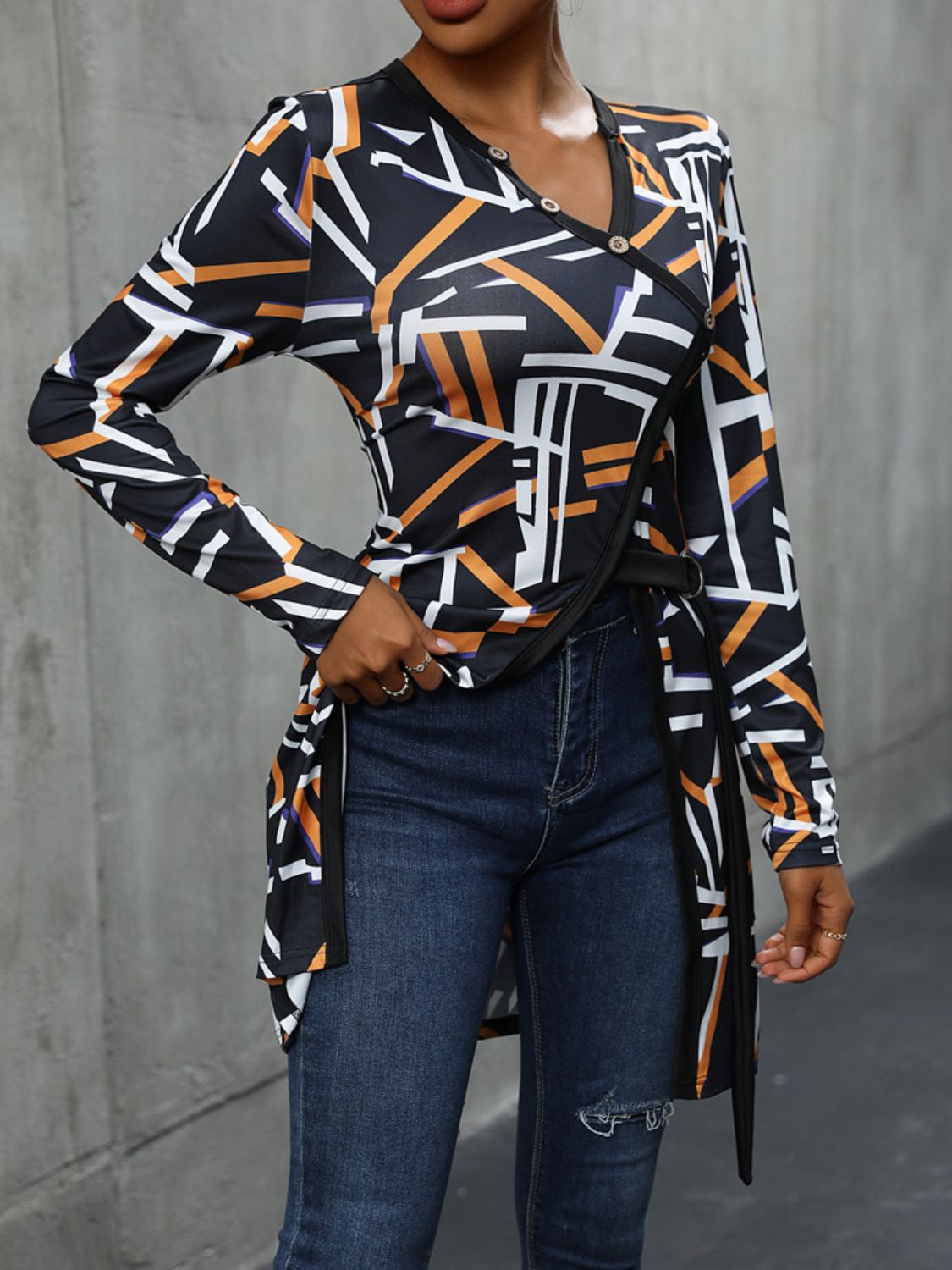 Black geometric print asymmetric blouse with decorative buttons and a tie waist.