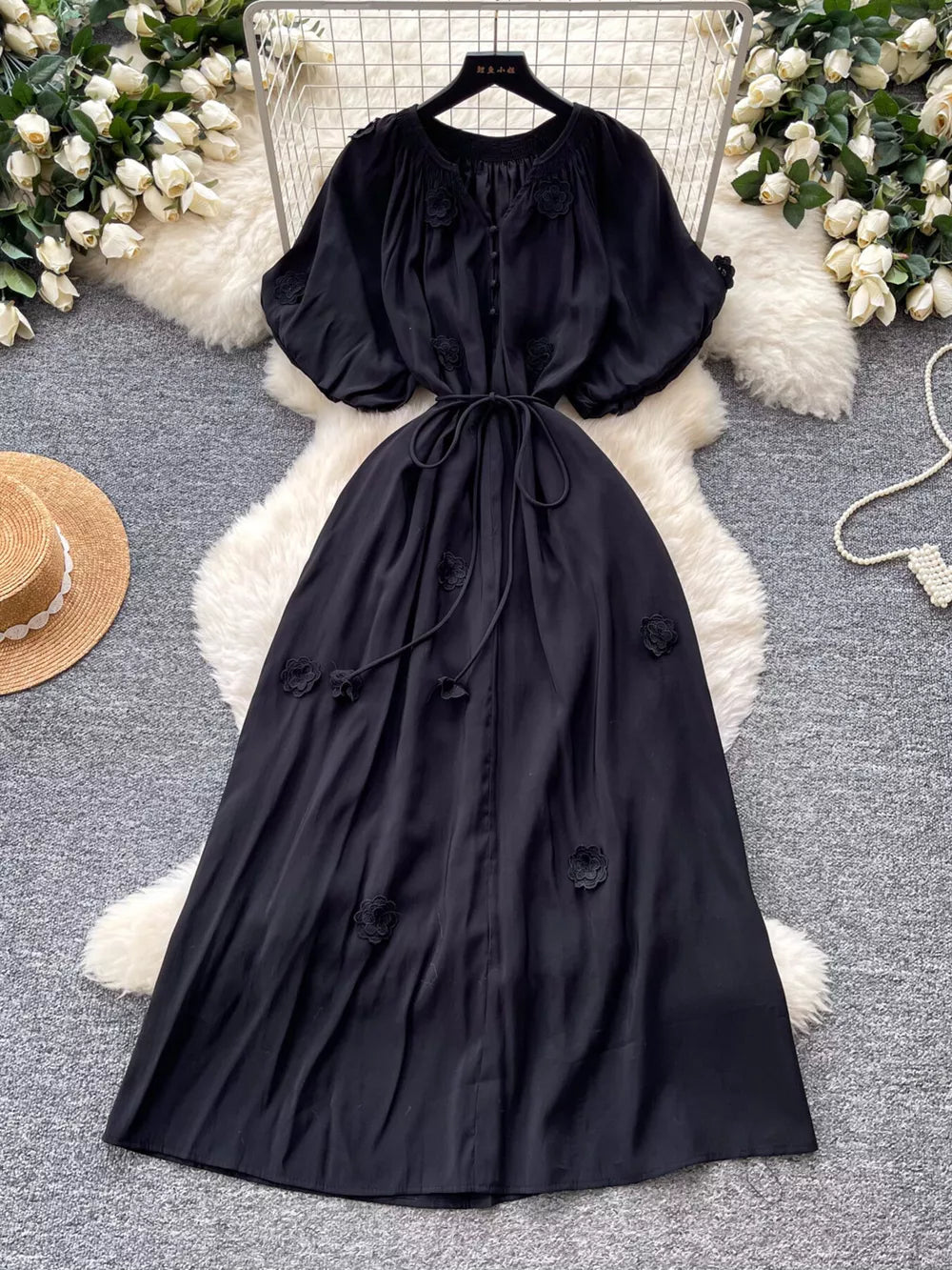 Black floral maxi dress with puff sleeves, V-neck, tie waist, and button front.