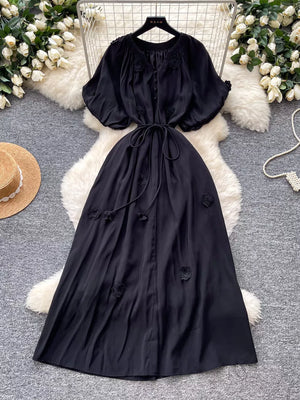 Black floral maxi dress with puff sleeves, V-neck, tie waist, and button front.