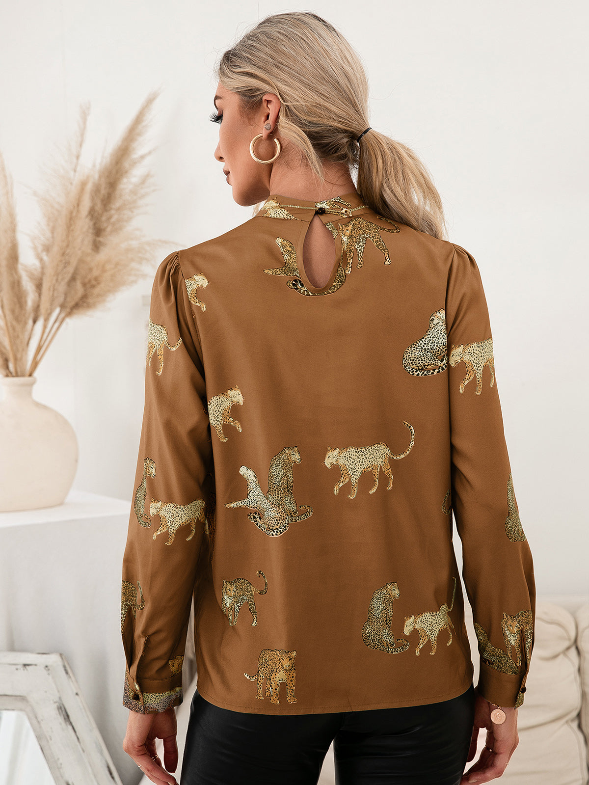 Caramel leopard print blouse with keyhole neck and puff sleeves.