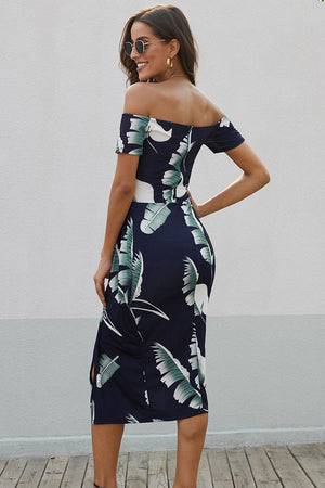 Off-shoulder midi dress in navy with a white and green leaf print, featuring short sleeves and a thigh slit.