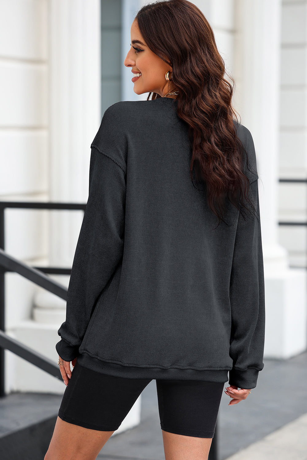Black ribbed knit sweatshirt with heart sequin detail on front