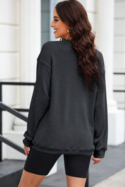 Black ribbed knit sweatshirt with heart sequin detail on front