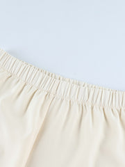 Cream lounge set pants with elastic waistband and black piping detail.