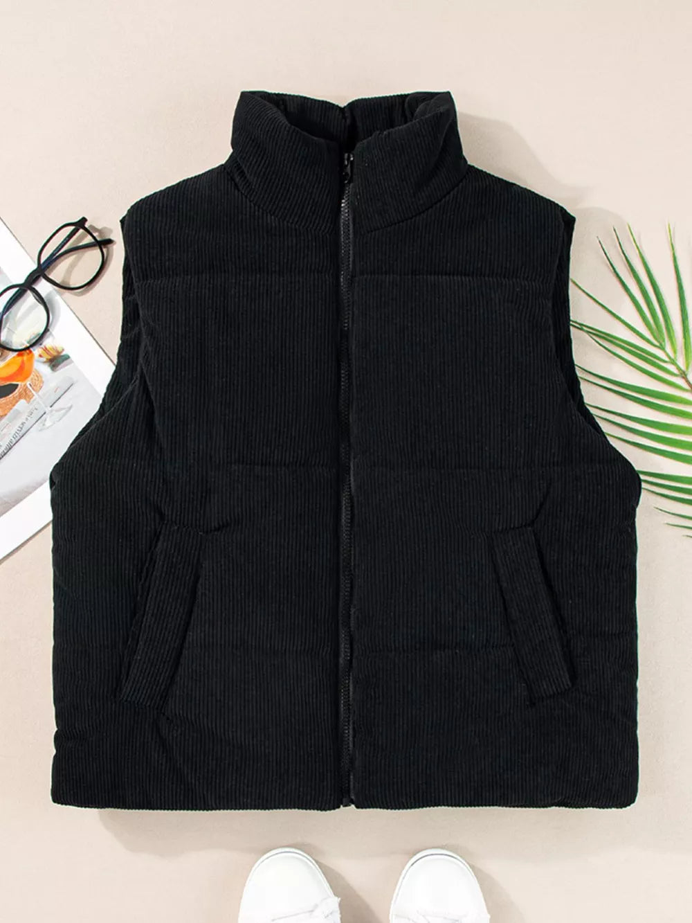 Black corduroy zip-up vest coat with stand-up collar and pockets.
