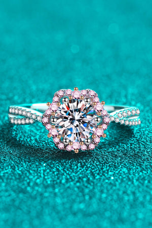 Silver moissanite ring with a floral halo of pink stones and a split band.
