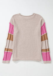 Beige knit sweater with color block panel sleeves in pink and brown.