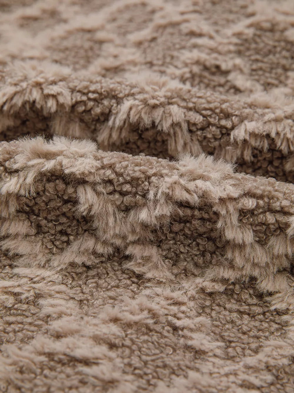 Textured sherpa fleece fabric in a taupe color with a soft, fuzzy pile.