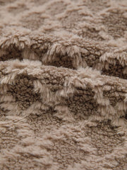 Textured sherpa fleece fabric in a taupe color with a soft, fuzzy pile.