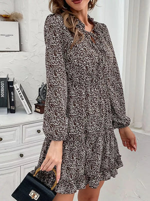 Ruffled tie neck floral mini dress in dark brown with long sleeves and a tiered hem.