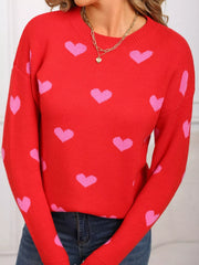 Red acrylic sweater with pink heart print and crew neck.