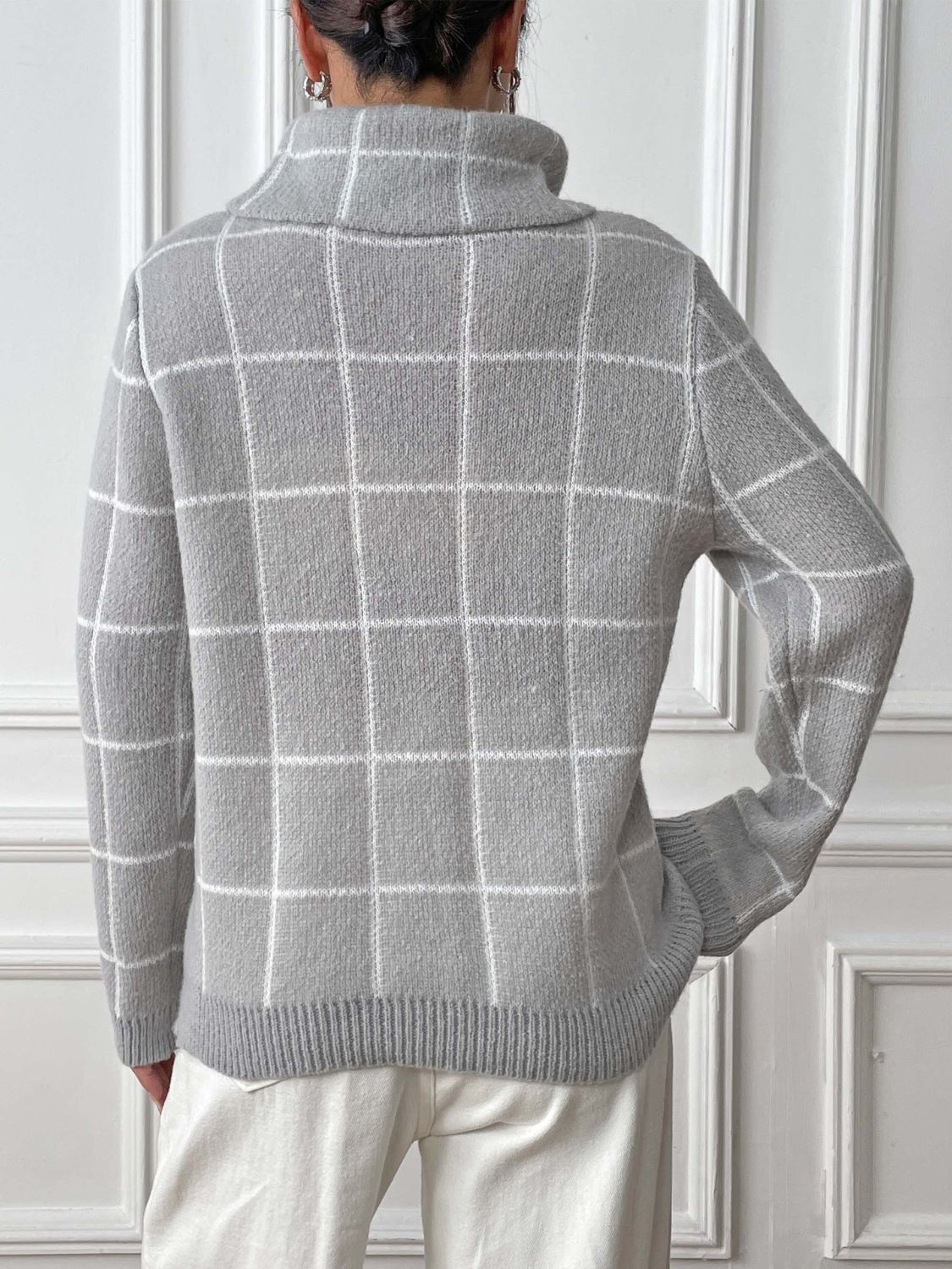 Light gray knit turtleneck sweater with white grid pattern and ribbed cuffs.