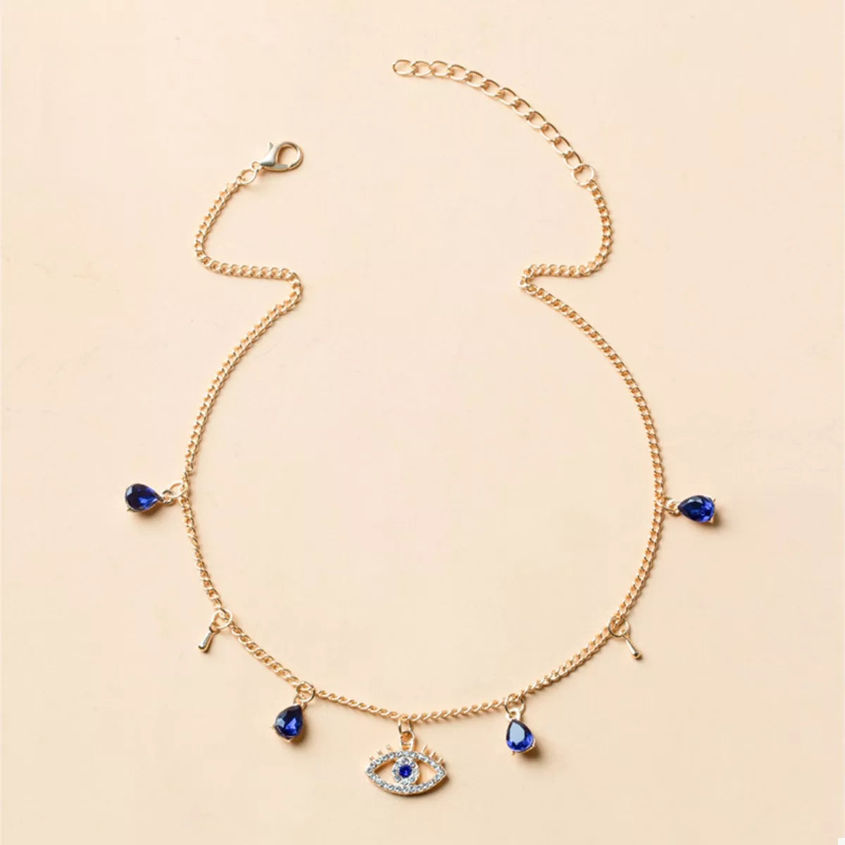 Gold evil eye charm necklace with blue crystal teardrops and key charms