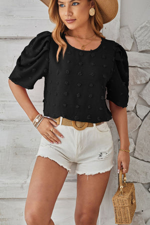 Black textured puff-sleeve blouse with pom-pom details and a round neckline.