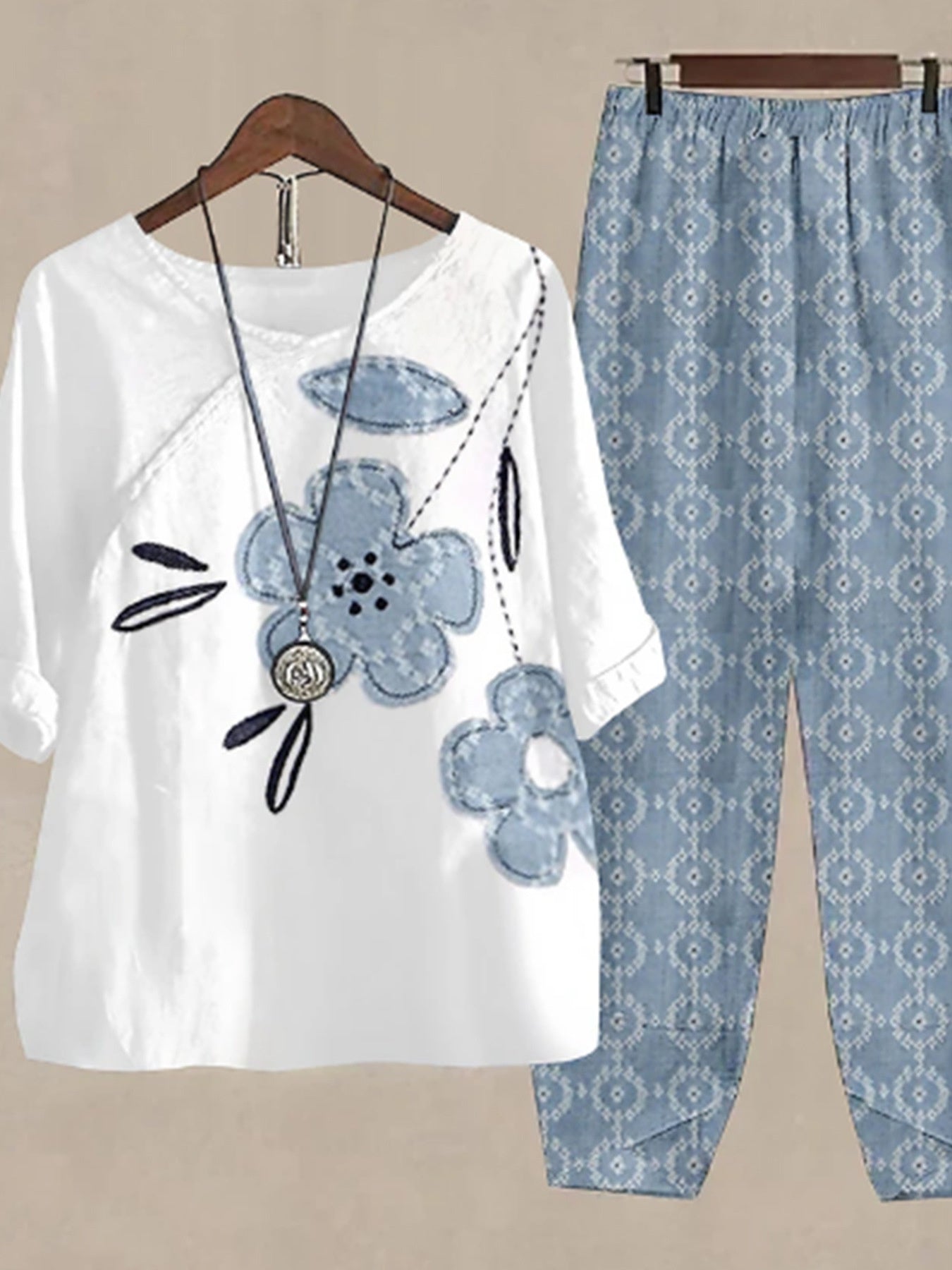 White floral print half sleeve top with blue floral appliques and matching patterned pants.