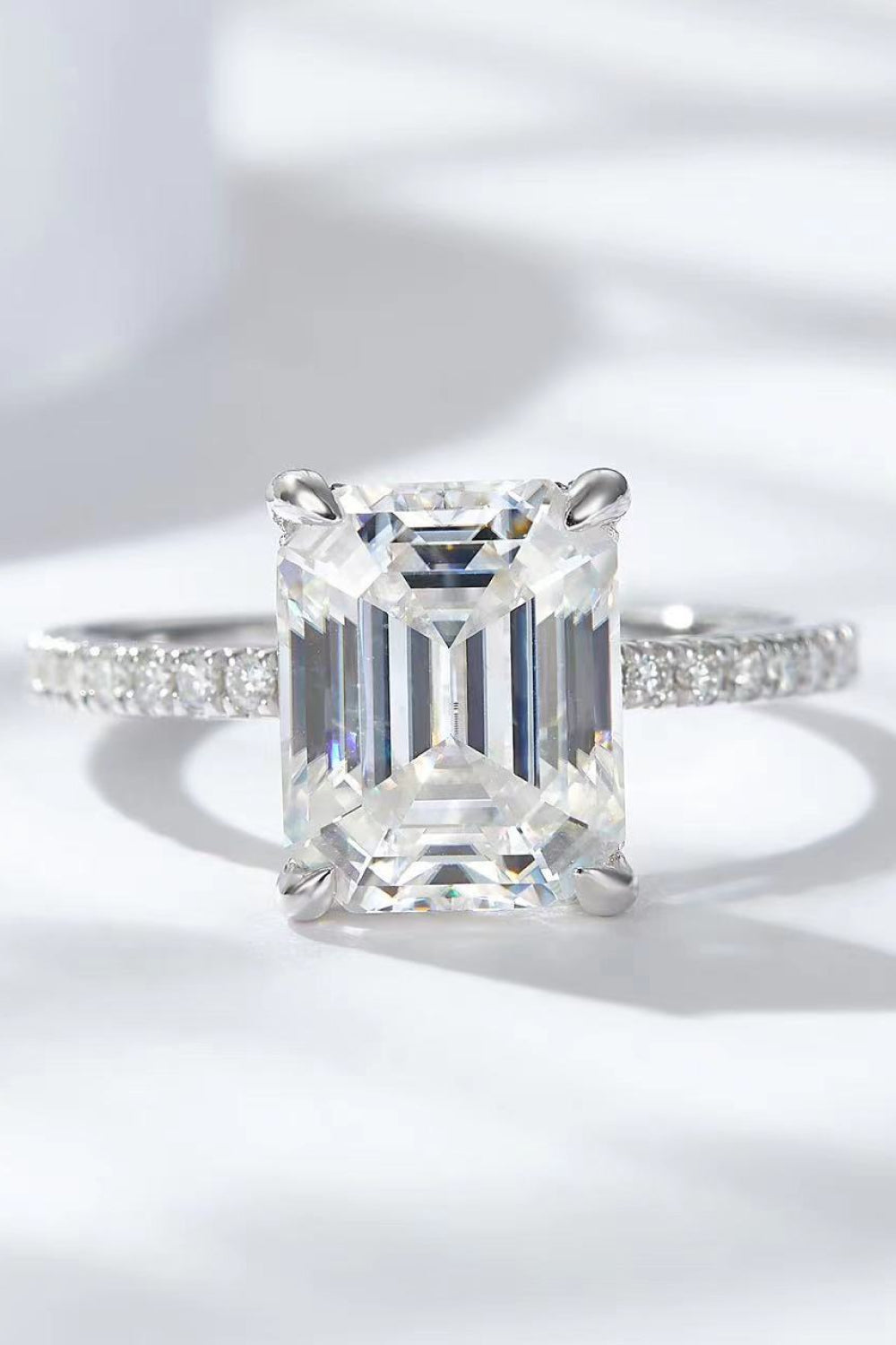 Sparkle Luxe Moissanite Halo Ring in silver with an emerald-cut center stone and pavé band.
