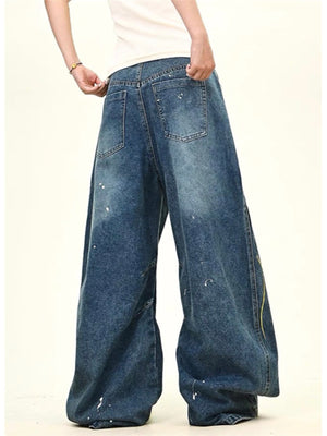 Oversized blue denim jeans with wide legs and paint splatters.