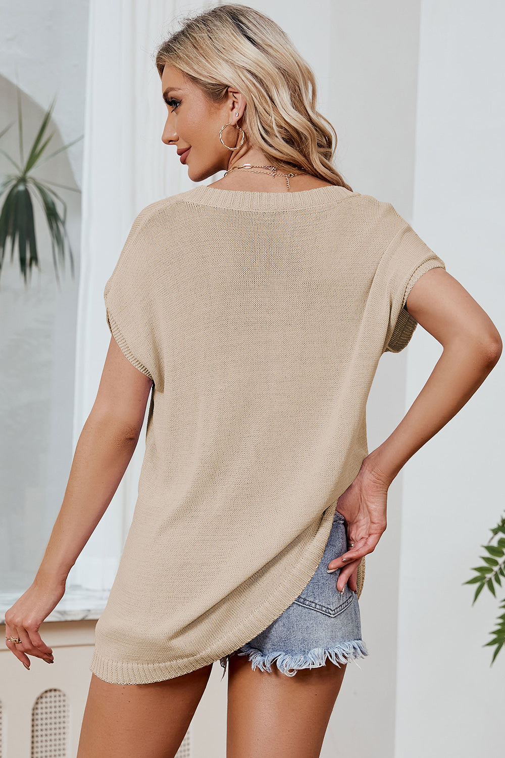 Tan knit tee with dolman sleeves and a relaxed fit, styled with denim shorts.