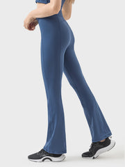 Dark blue activewear pants with a flared leg and zip detail, shown from the side.