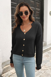 Black acrylic knit cardigan with scalloped V-neck and button front.