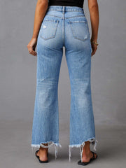 Light blue distressed flare jeans with raw hemline and ripped details.