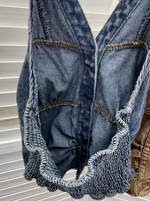 Blue denim halter top with gathered detail and textured ruffle hem.