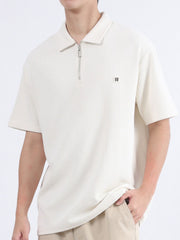 Textured apricot polo shirt with zipper detail and short sleeves