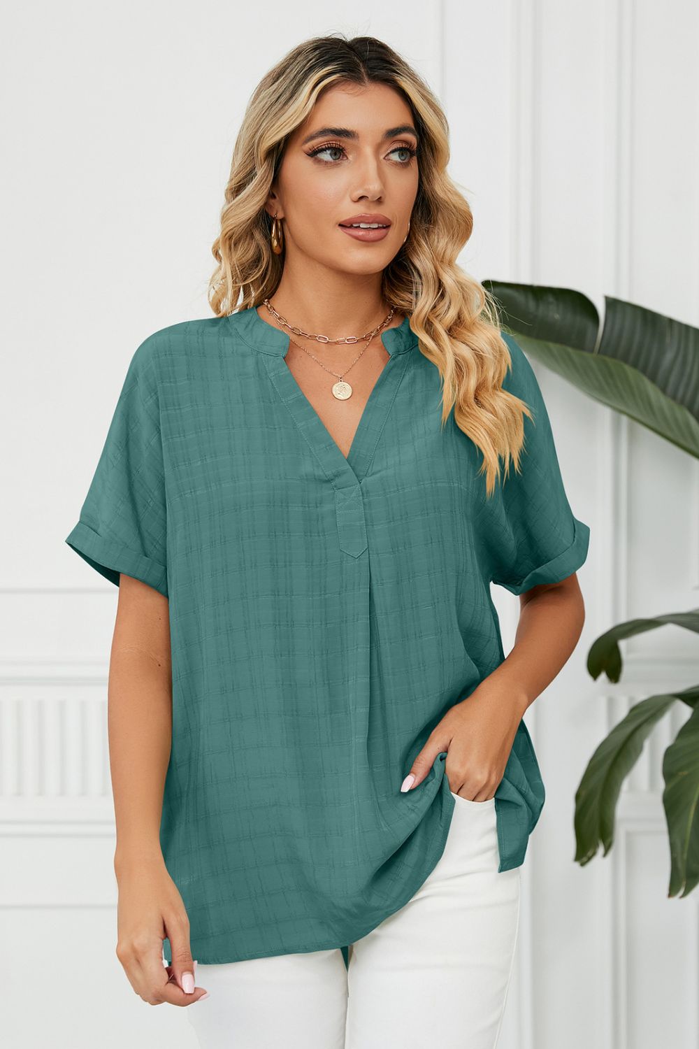 Turquoise linen blouse with V-neck and short sleeves, subtle plaid texture.