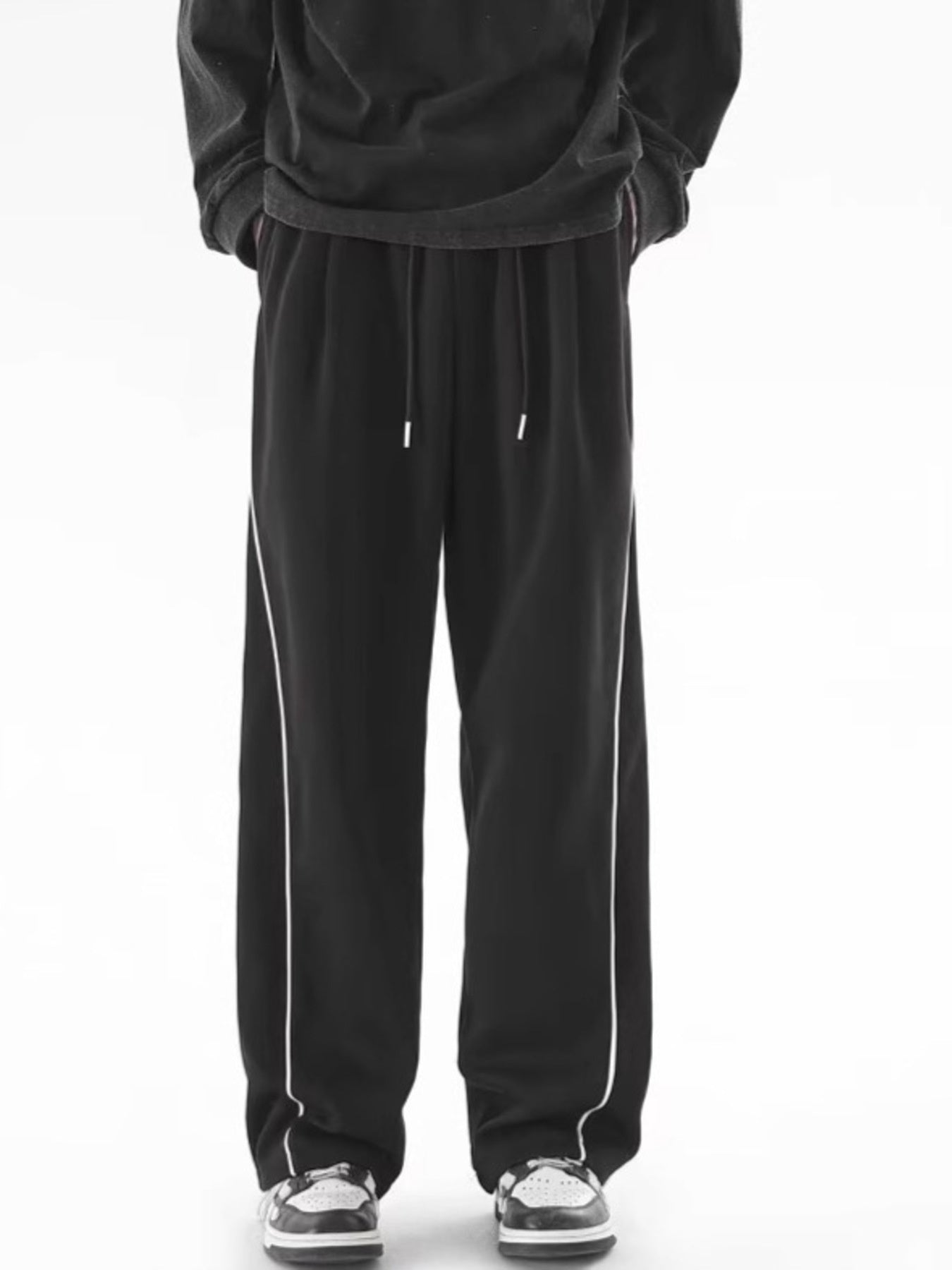Men's black relaxed fit sweatpants with white side stripes and drawstring waist.
